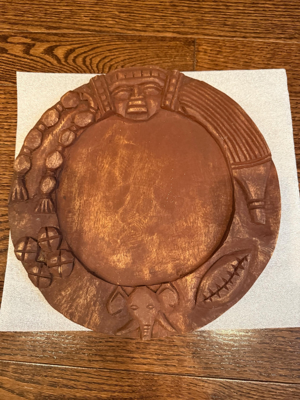 Wooden plaque with decorative carvings on a wooden surface